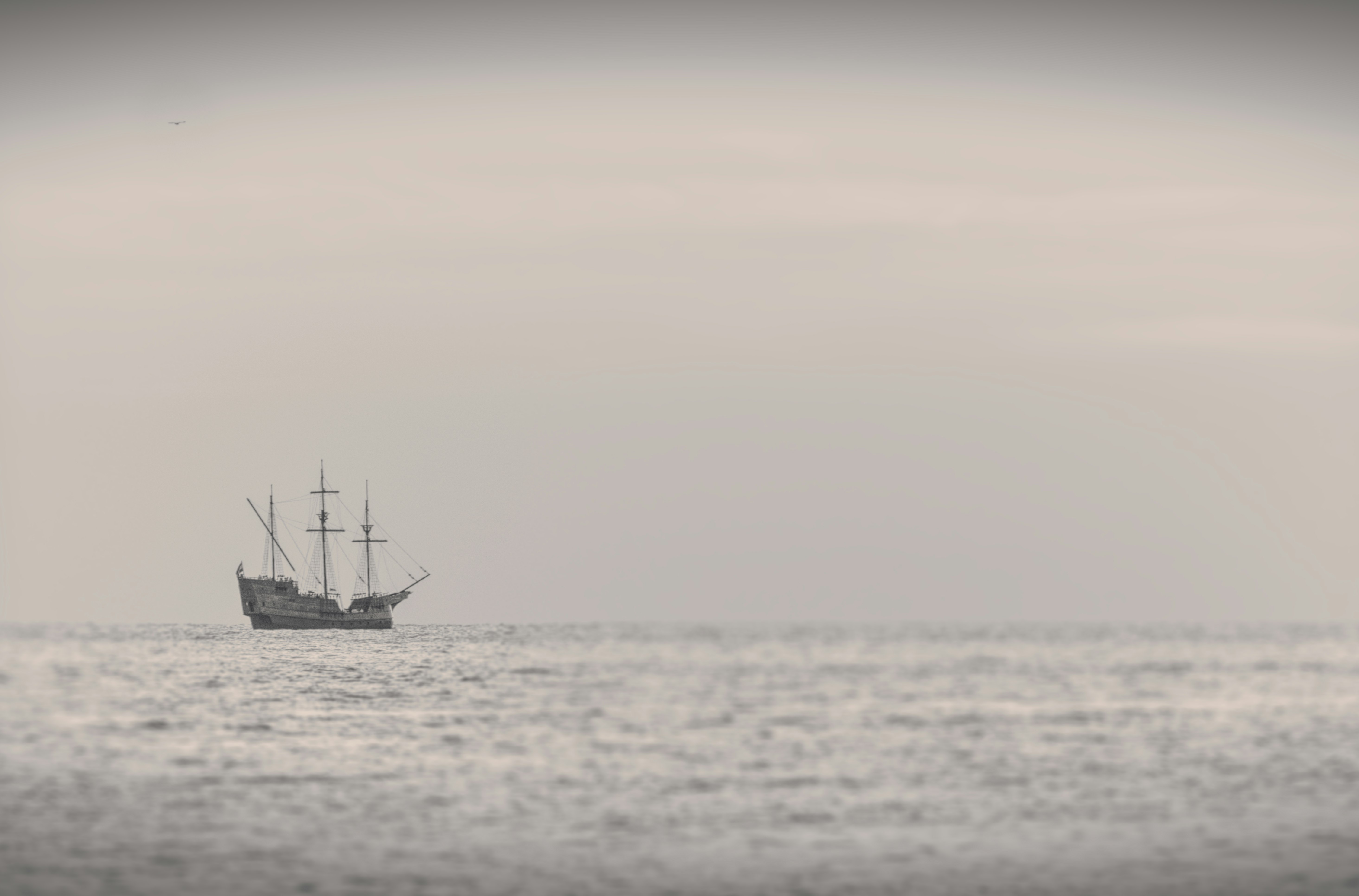 black boat on sea under white sky during daytime